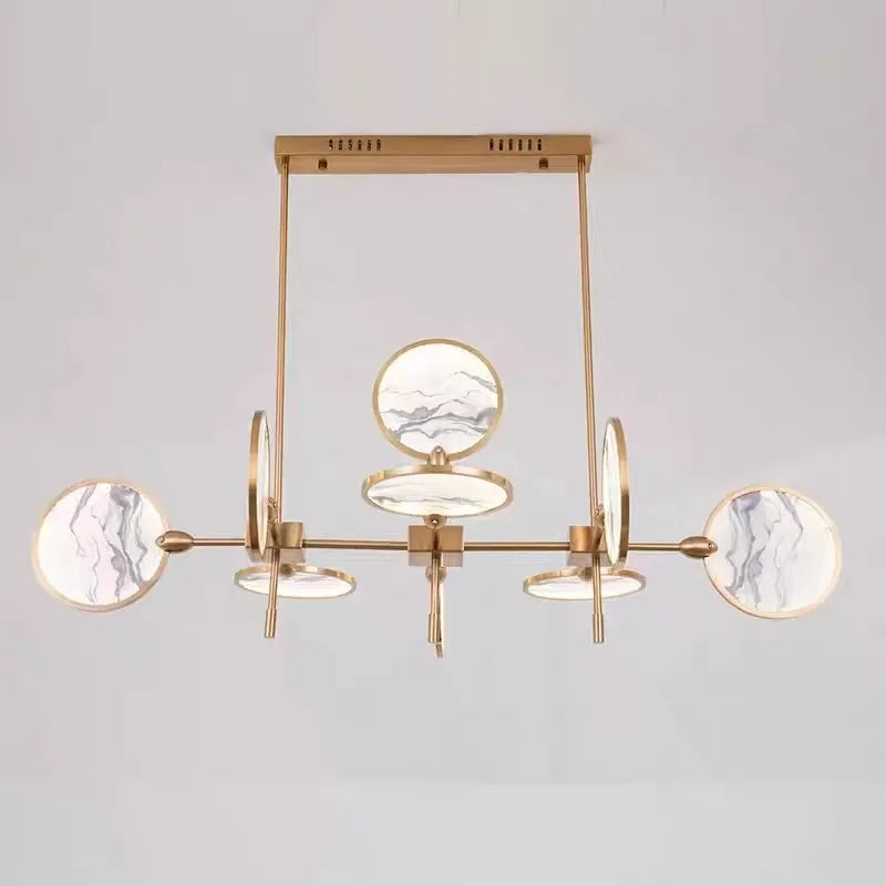 Modern chandelier with gold frame and marble-like finishes on a light gray background