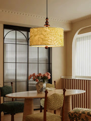 Green floral fabric drum pendant light with wood accents over a dining table