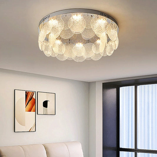 Round chrome ceiling light with multiple layers of clear textured glass discs and visible LED bulbs