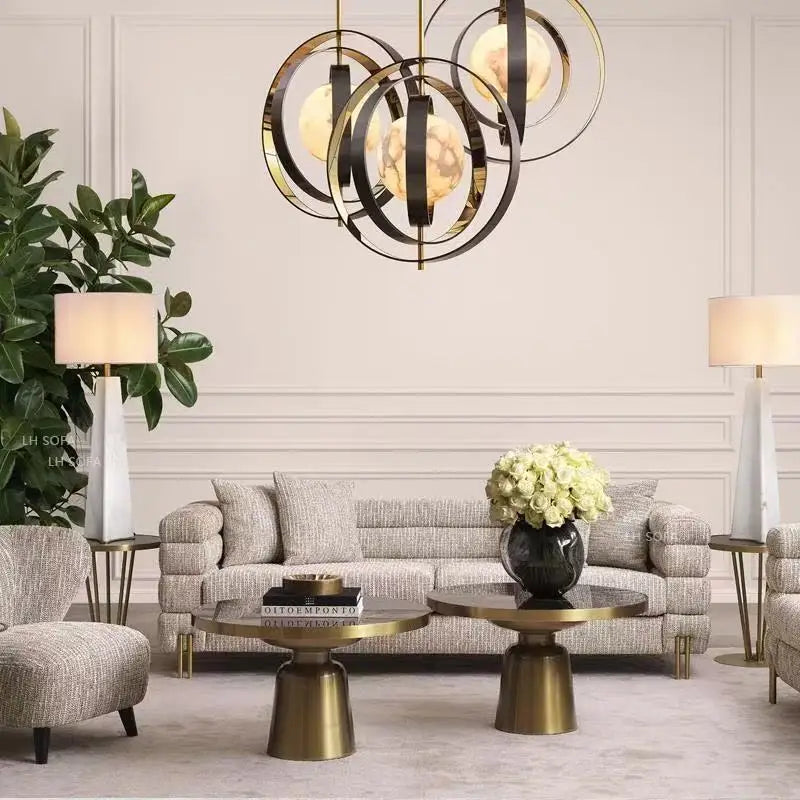 Modern living room with a chandelier, sofa, and decorative elements.