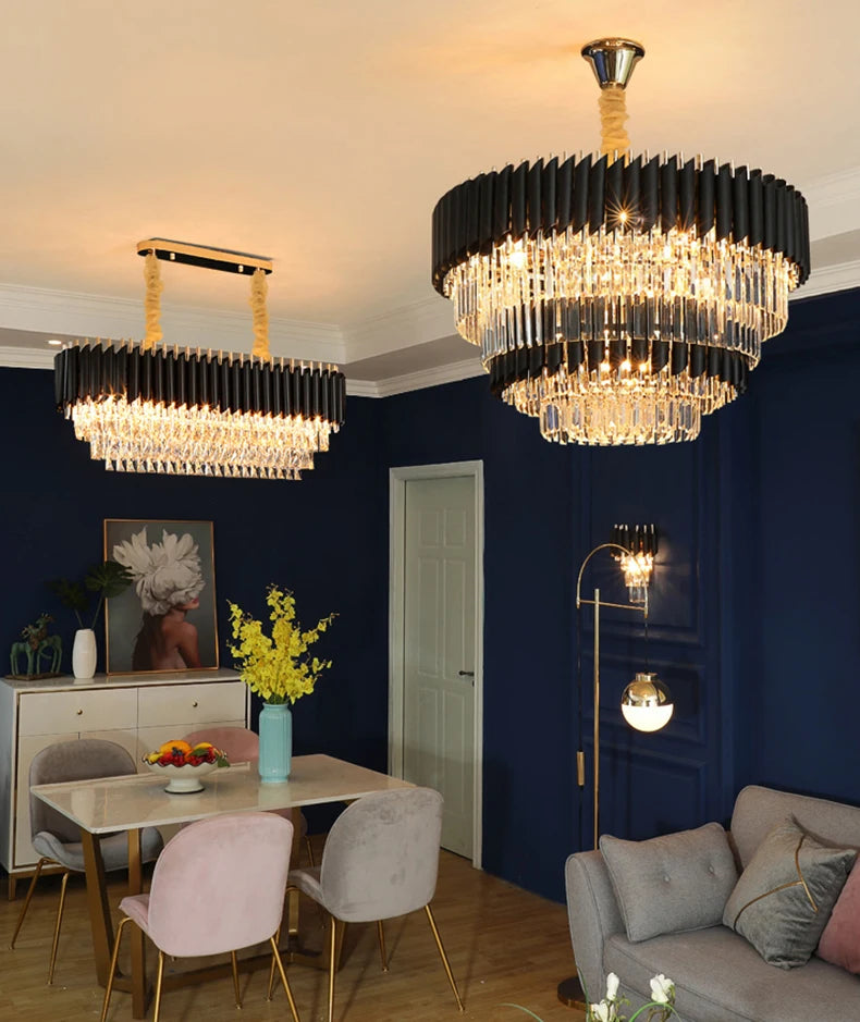 Dining room with two modern chandeliers, a table with flowers, and a sofa.