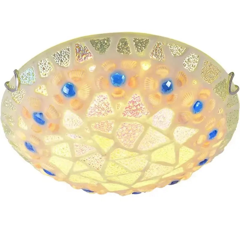 A mosaic glass seashell flush mount ceiling light illuminated from within, showcasing pastel tones and blue gem details