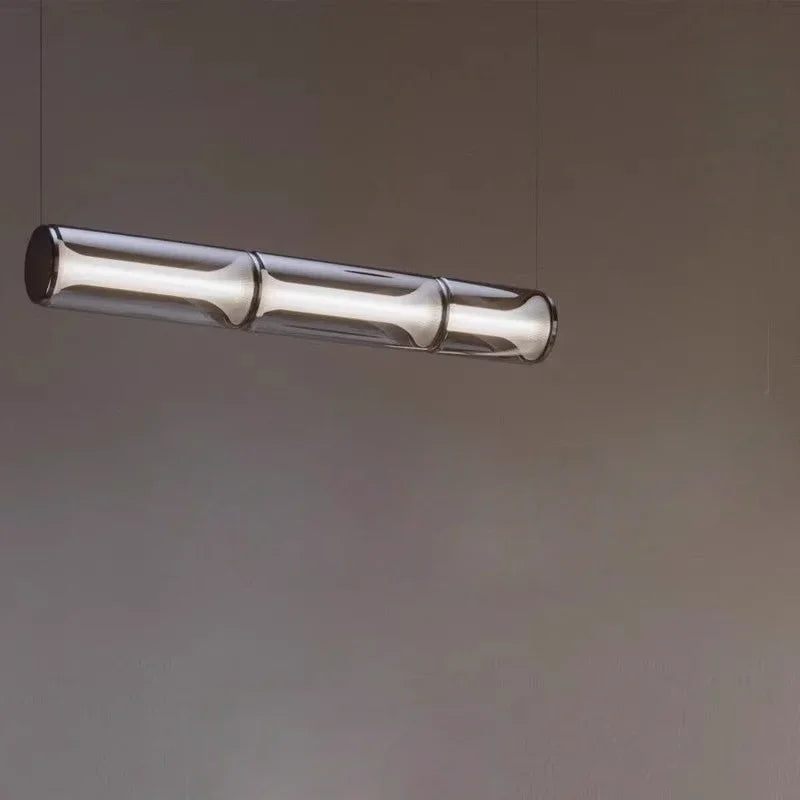 Modern pendant light with cylindrical design on a plain background