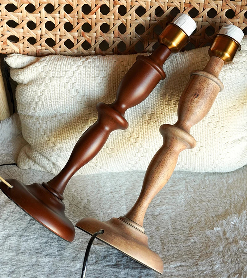Two wooden candlesticks with gold accents on a textured surface.