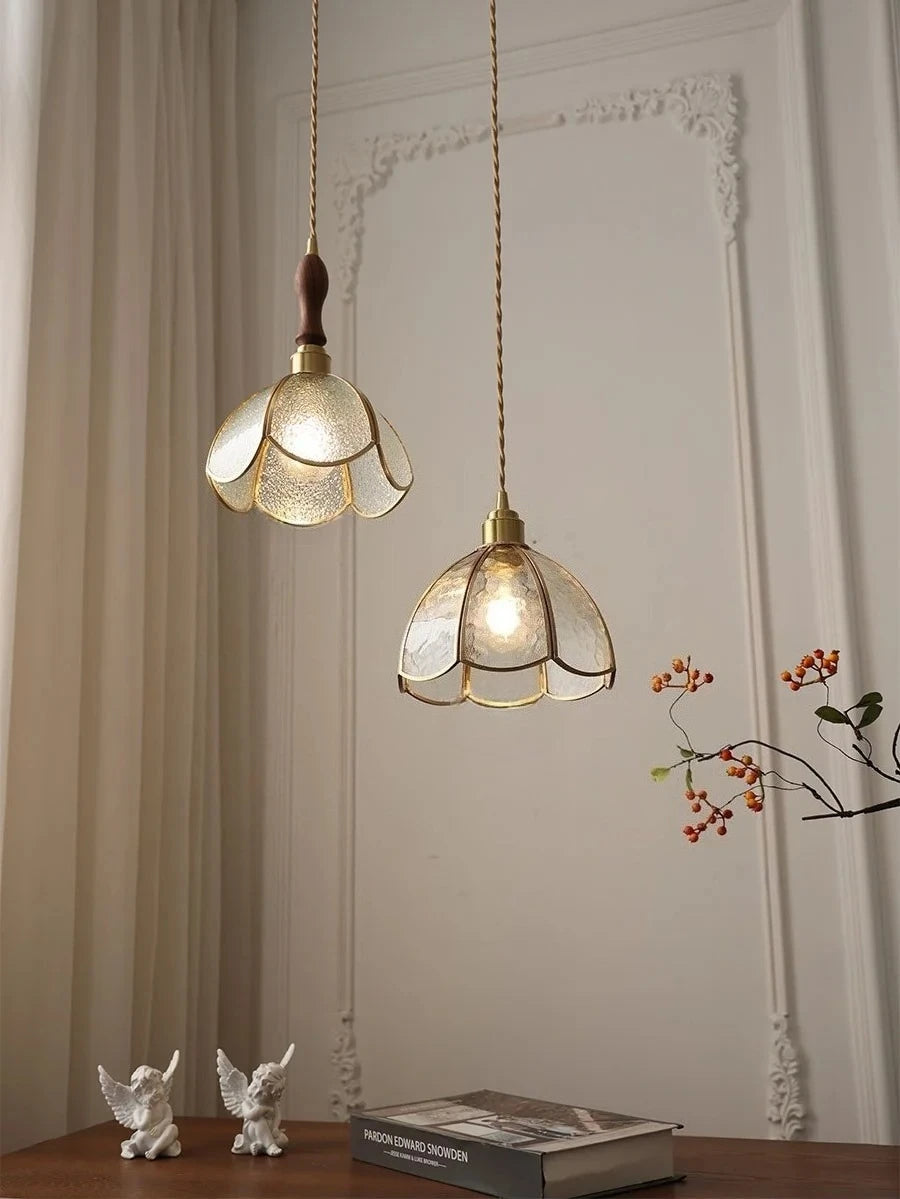 Two hanging pendant lights with floral glass shades in a room setting.
