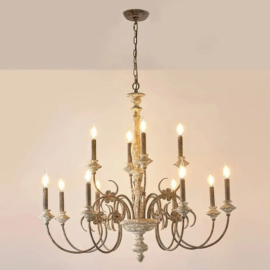 Distressed wood candle-style chandelier with floral accents against a white background