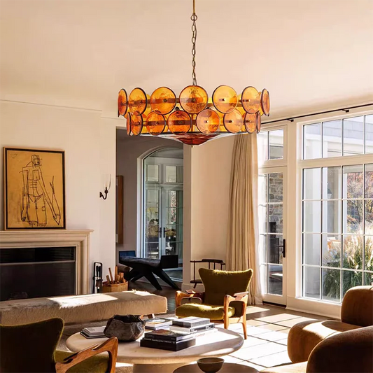Amber glass disc chandelier hanging in a living room.