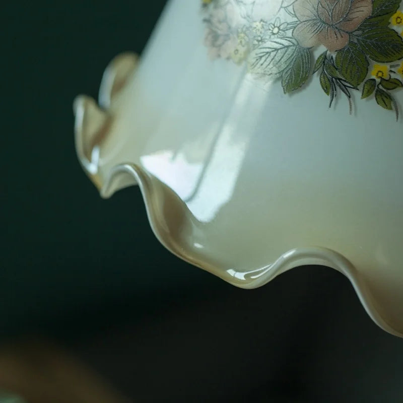 Close-up of a ceramic teapot with floral design on a dark background