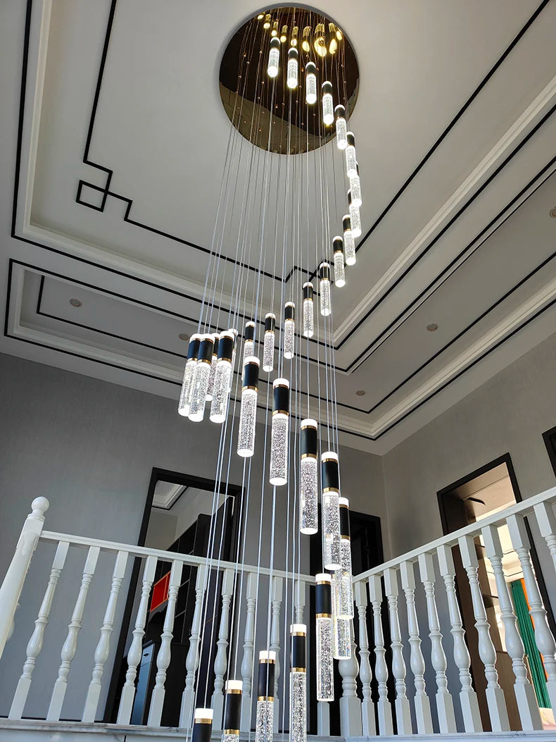 Modern chandelier hanging from a ceiling in a well-lit room with a staircase.