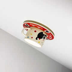 Close-up view of the ceramic coffee cup ceiling light showing the cat illustration and colorful dots