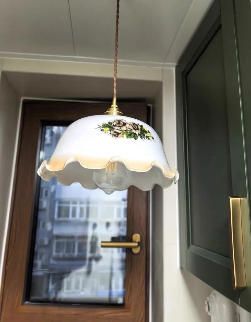Decorative pendant light with floral design in a room with a door and window.