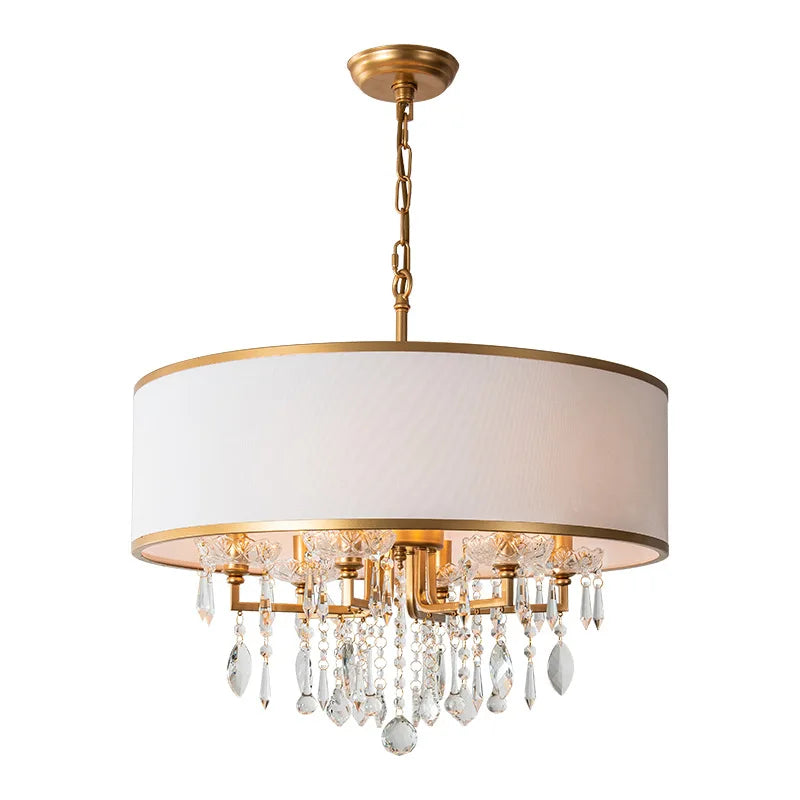 Front view of a gold drum shade chandelier with cascading clear crystals against a white background.