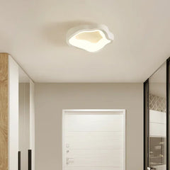 White wavy-shaped ceiling light mounted on a neutral ceiling with a white door in the background