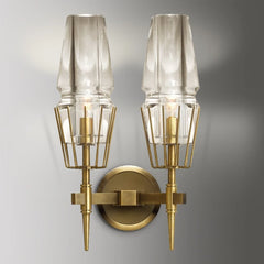 Pair of clear glass crystal wall sconces with brushed gold frames mounted side-by-side.
