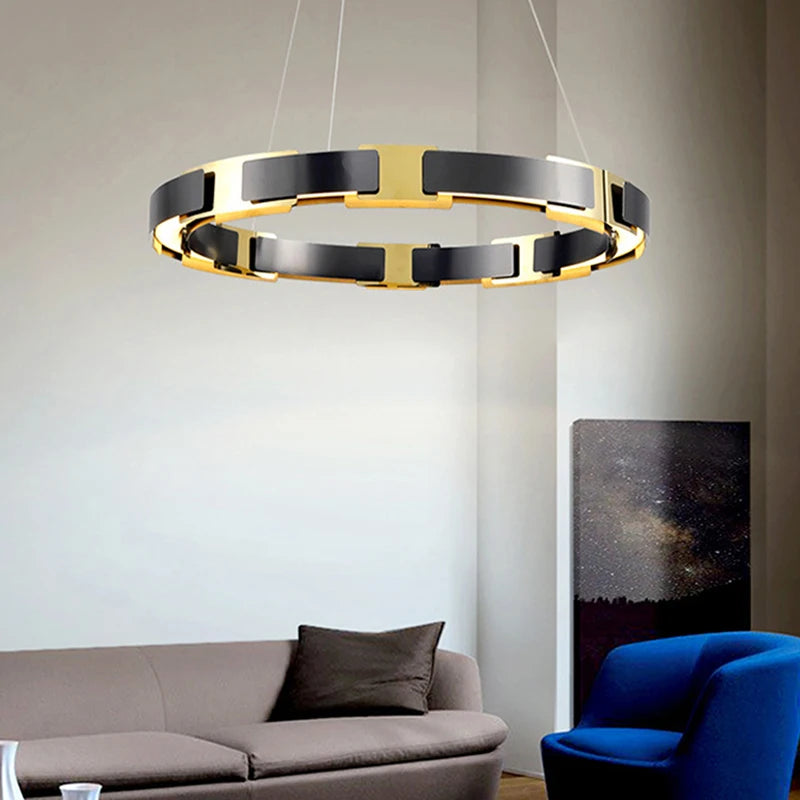 Modern chandelier hanging in a living room with a gray sofa and blue chair.