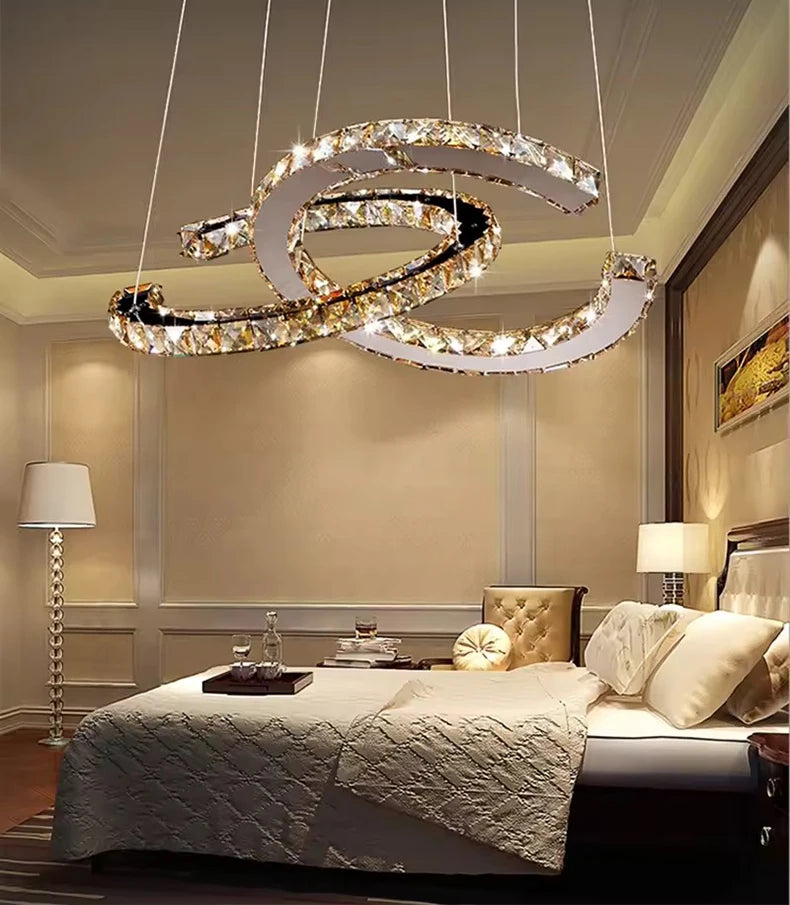 Modern chandelier hanging above a bed in a bedroom setting