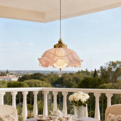 A gold floral pendant light with crystal accents suspended over an outdoor seating area.