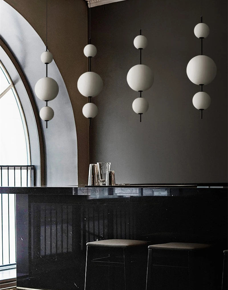 Modern interior with black bar, white spherical pendant lights, and dark walls.