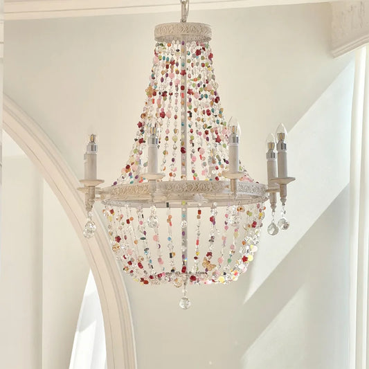 White multi-arm chandelier with cascading colorful beads and clear crystals, hanging from a white ceiling.