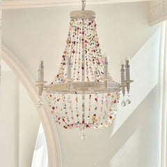 White multi-arm chandelier with cascading colorful beads and clear crystals, hanging from a white ceiling.