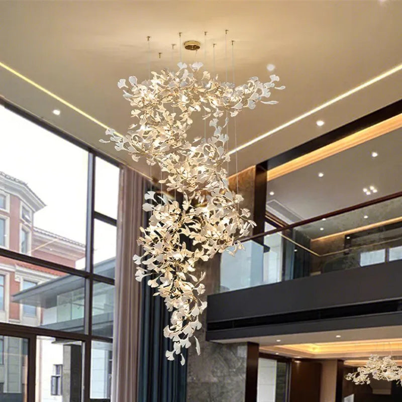 Luxurious interior with a gold ginkgo leaf chandelier suspended from a high ceiling.
