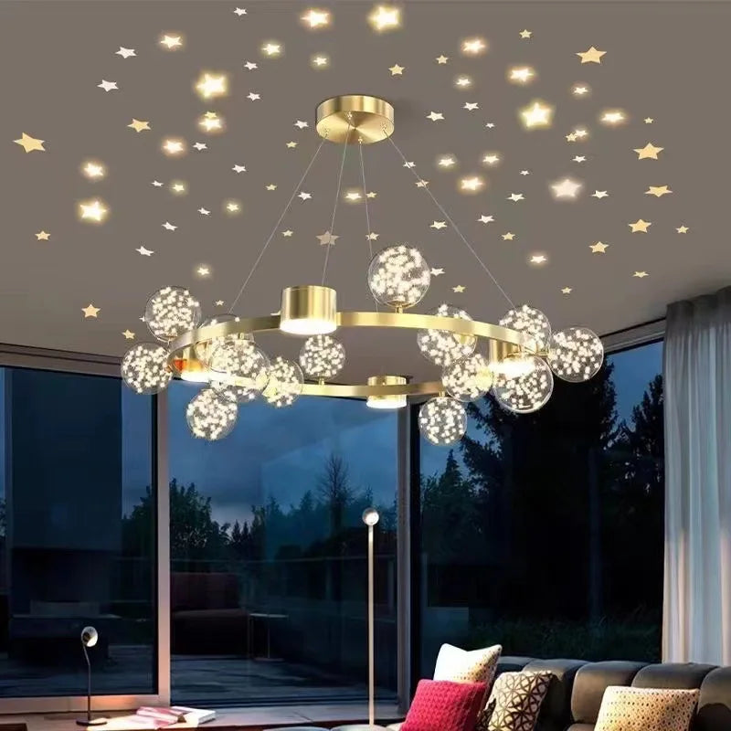 View of a gold starburst chandelier in a living room at night, with stars visible on the ceiling and the chandelier's lights reflecting.