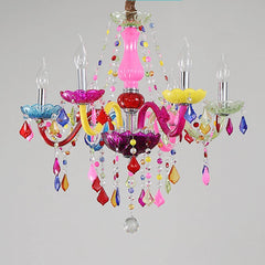 A brightly colored chandelier with ornate arms, crystal drops, and five illuminated bulbs, showcasing its festive and playful design.