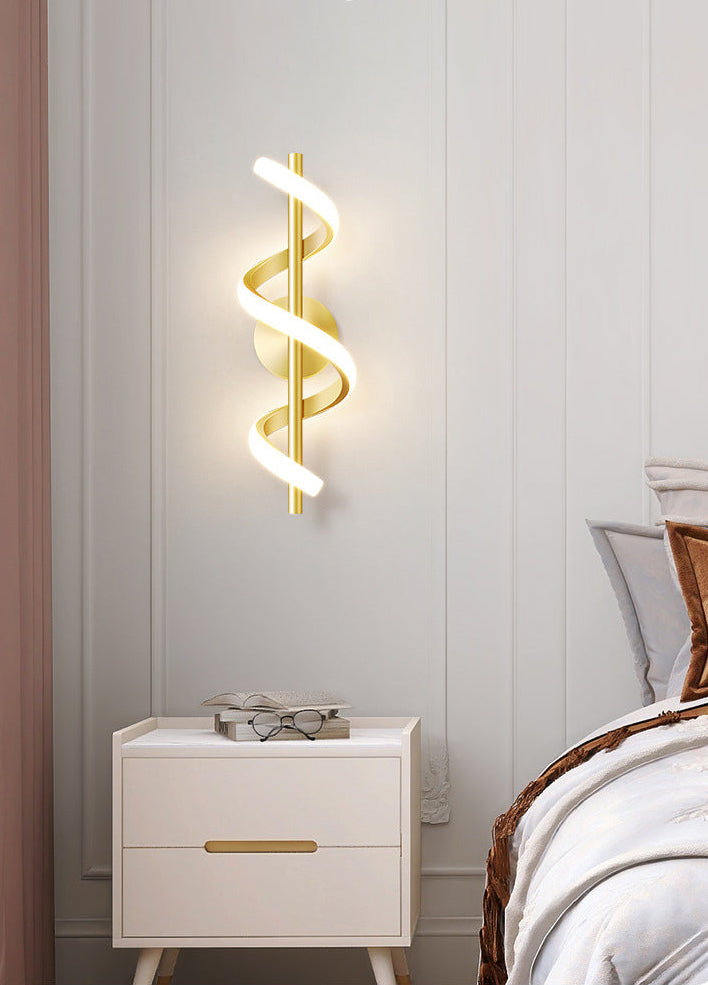Modern wall light fixture on a bedroom wall with a nightstand and bed in the background.