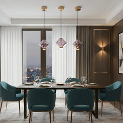 Three purple glass pendant lights with brushed gold fittings suspended over a dining table.