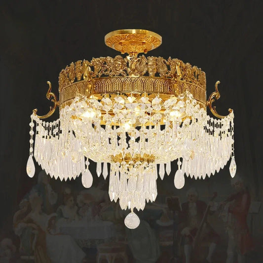 Close-up of a gold semi-flush ceiling light showcasing intricate metalwork and clear crystal pendants against a dark background.