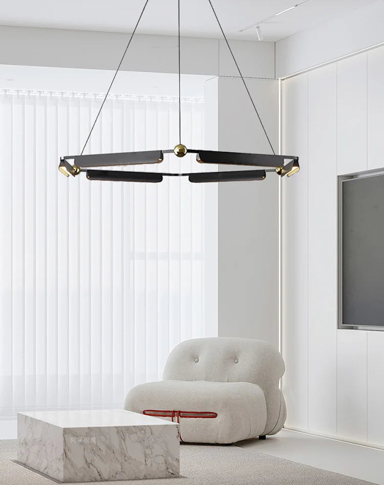 Modern chandelier hanging above a white armchair in a minimalistic room.