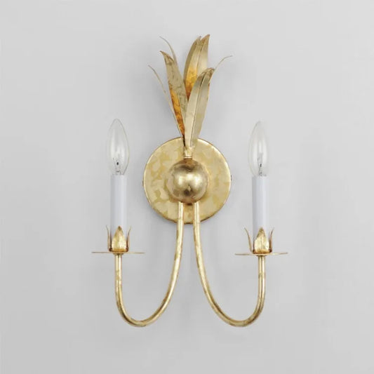 Front view of a gold leaf wall sconce mounted on a white wall