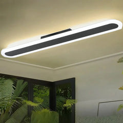 Long, thin, white and black linear ceiling light mounted on a neutral ceiling.