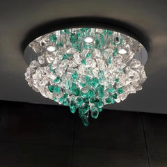 Close-up view of the cascading clear and green crystals on a modern flush mount ceiling light.