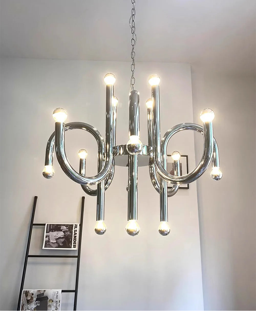 Modern chrome chandelier hanging against a plain wall.