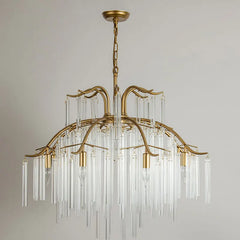 A wide shot of the gold glass rod tiered chandelier hanging in a well-lit room with natural light from windows.