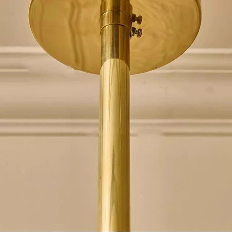 Gold lamp with a cylindrical base and round top on a beige background