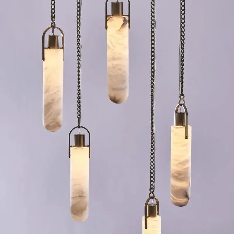 Set of pendant lights with cylindrical glass shades on a plain background