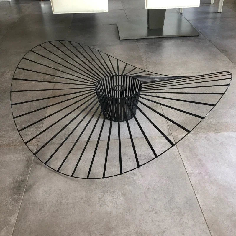 Black metal fire pit with decorative design on a tiled floor