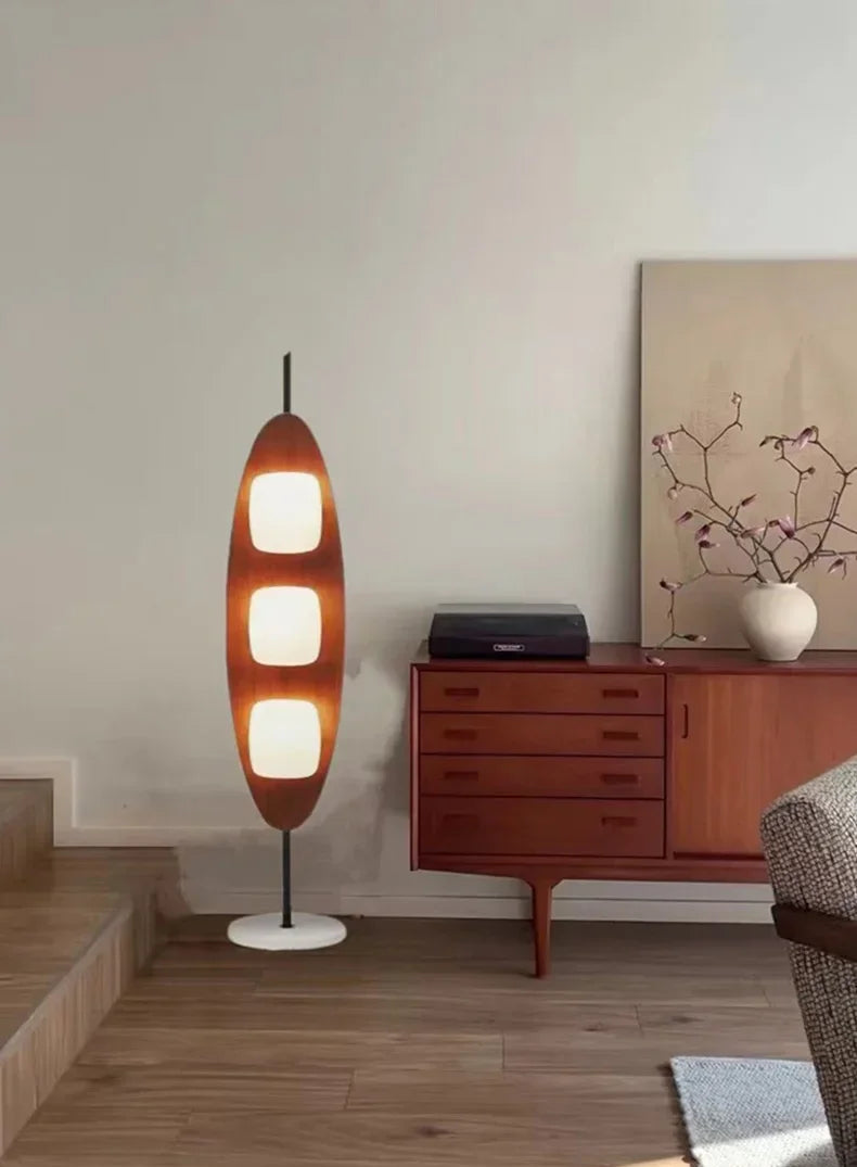 Modern living room with a unique floor lamp and wooden furniture.