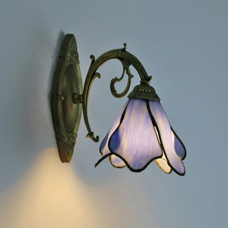 Decorative wall lamp with stained glass shade on a plain background