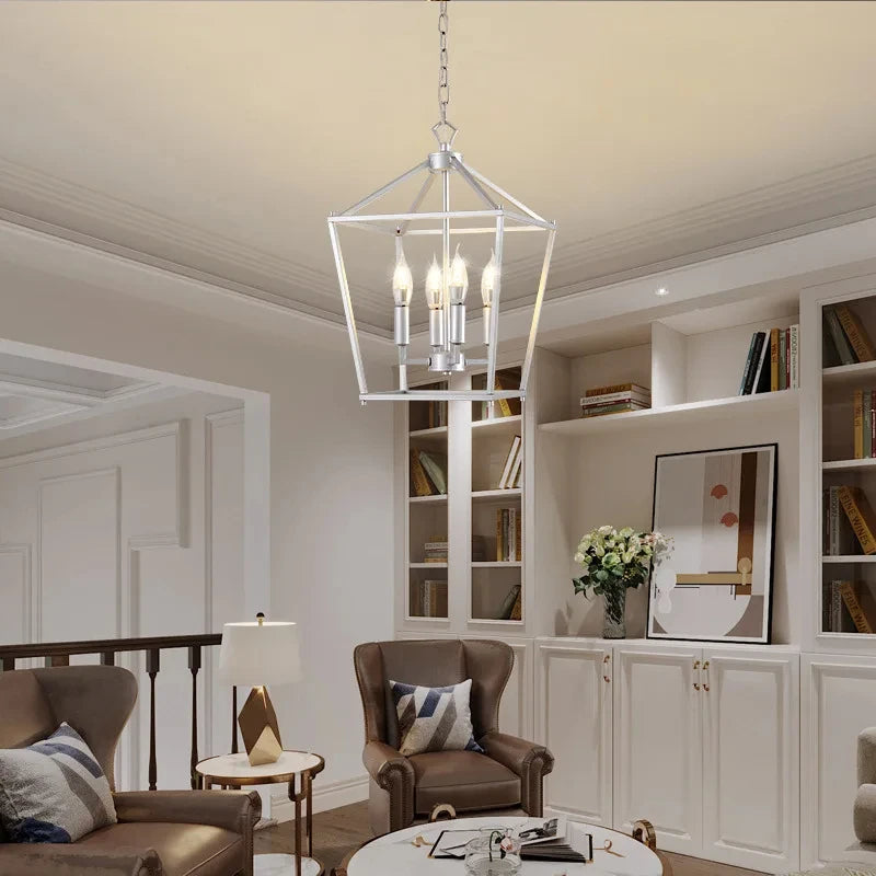A silver geometric cage pendant light hanging in a living room with brown leather armchairs and built-in bookshelves.