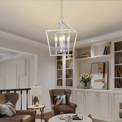 A silver geometric cage pendant light hanging in a living room with brown leather armchairs and built-in bookshelves.