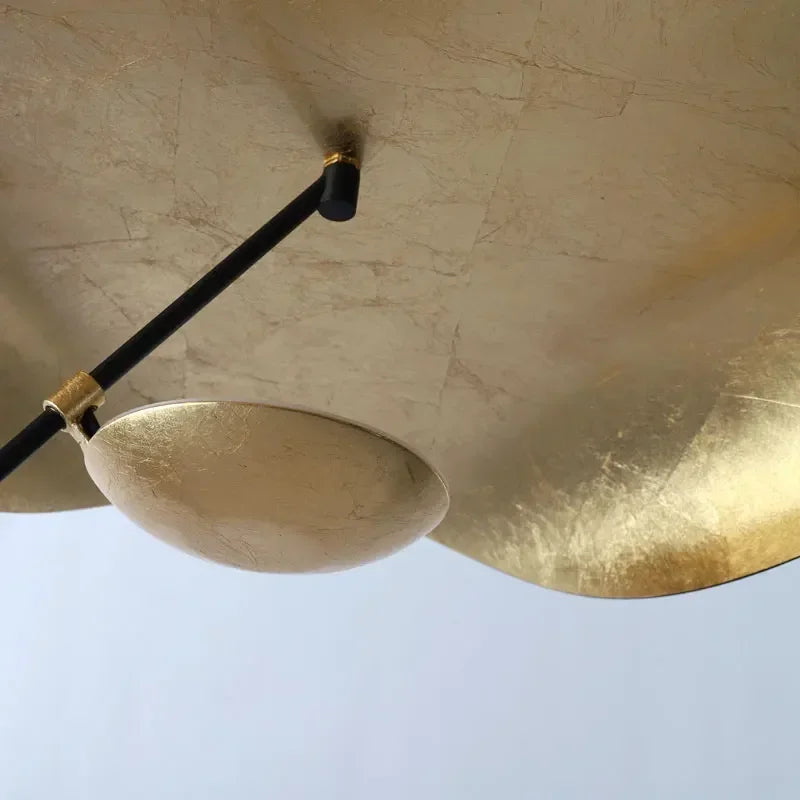 Close-up of a gold ceiling light fixture against a blue sky background