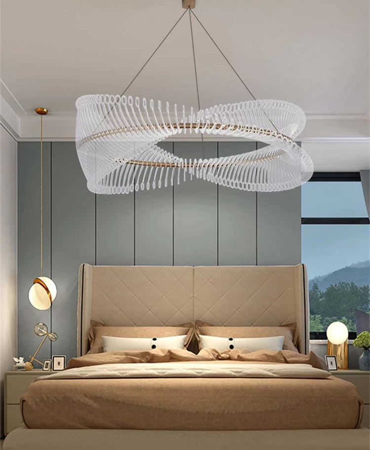 Modern bedroom with a large chandelier, bed, and wall decor.