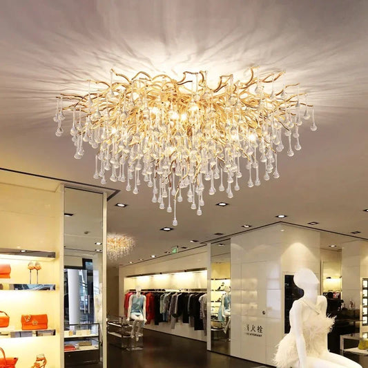Close-up of the gold frame and cascading crystal droplets of the chandelier, with light reflecting off the crystals.