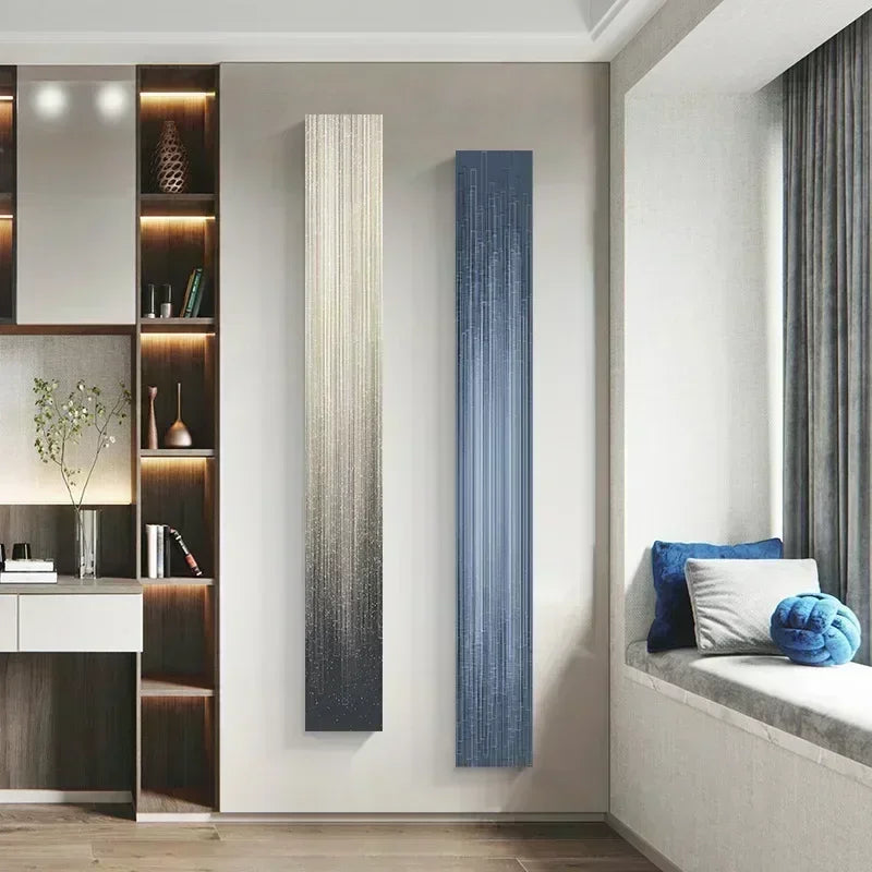 Tall vertical radiator against a wall in a modern room with a window seat and decorative pillows.