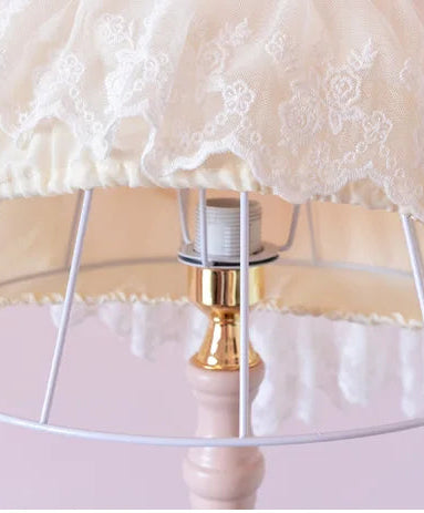 Decorative lamp with lace shade on a pink background
