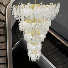 Close-up view of a gold chandelier featuring numerous crystal droplets arranged in tiered levels.