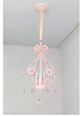 A pink crystal chandelier with rose accents hanging from a ceiling.